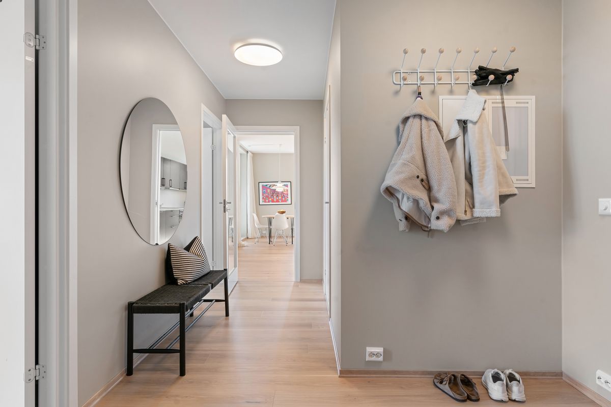 Minimal hallway with coats shoes mirror and organized storage