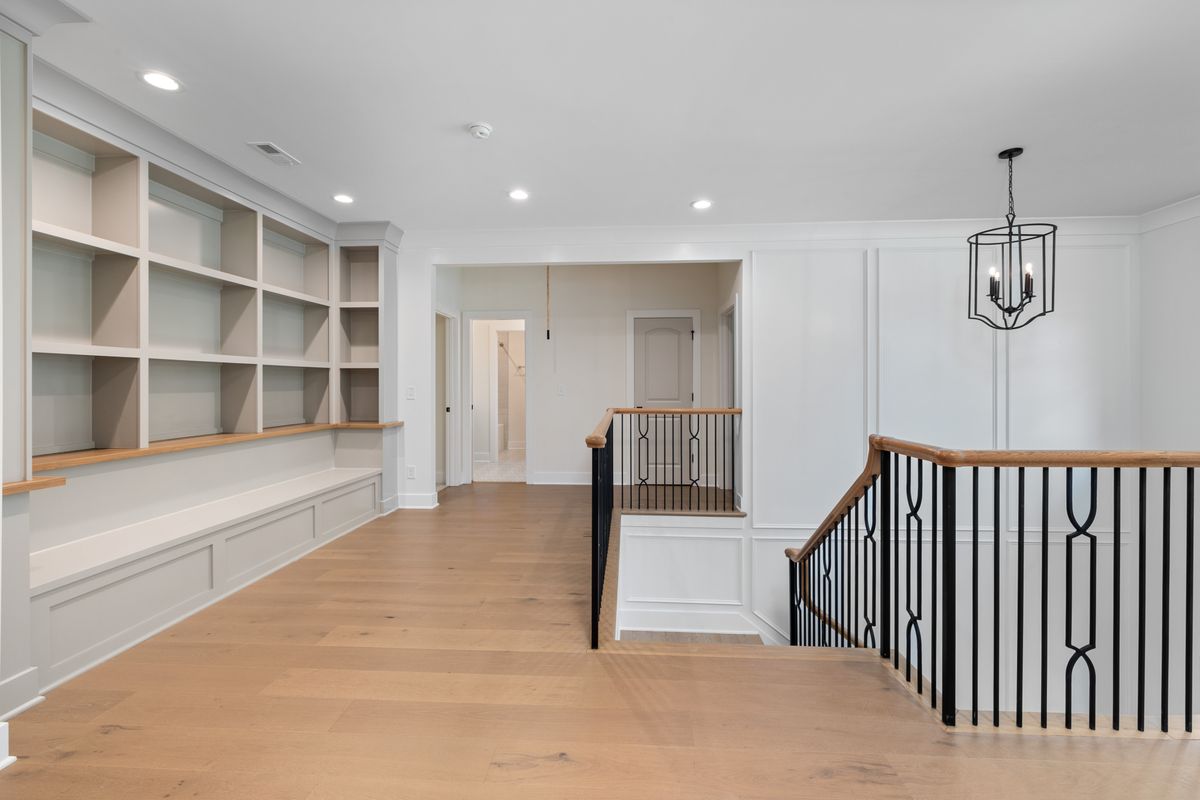 Bright modern foyer with custom shelving and staircase