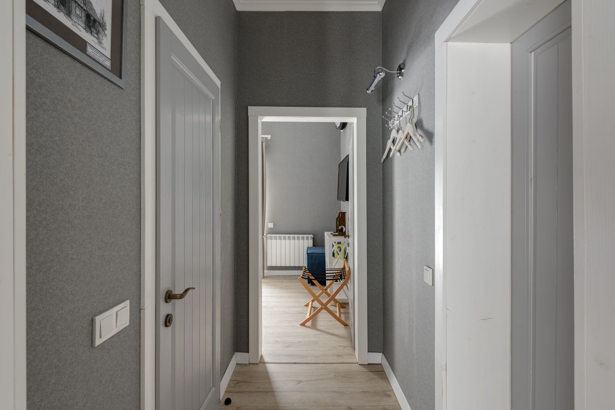 Spacious organized hallway with hooks and wooden doors