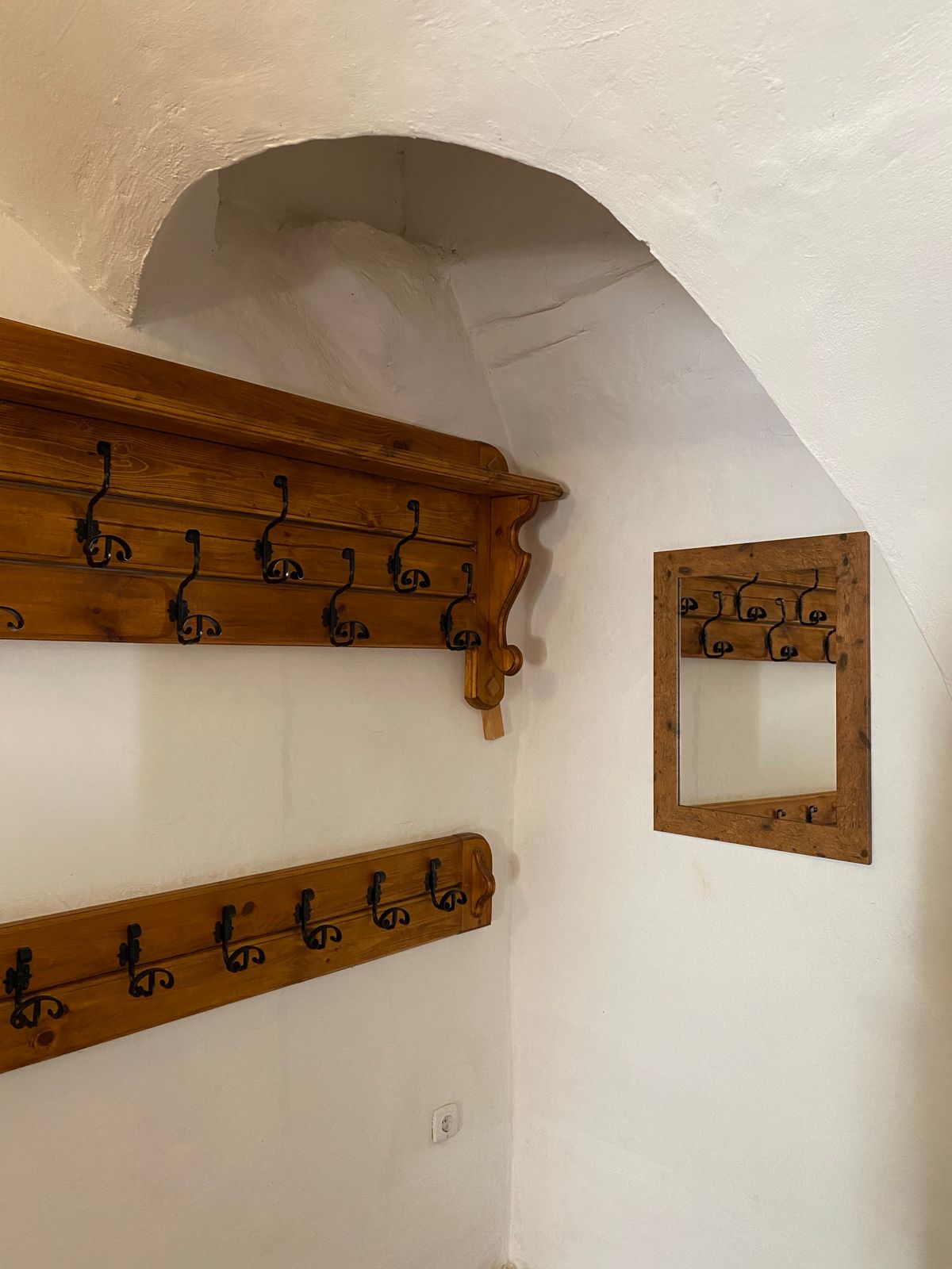 Wooden wall mounted coat rack with hooks in an entryway